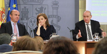 Luis de Guindos y Jorge Fernández Díaz en rueda de prensa junto a Soraya Sáenz de Santamaría