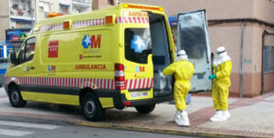 Ambulancia y enfermeros con trajes especiales para el ébola