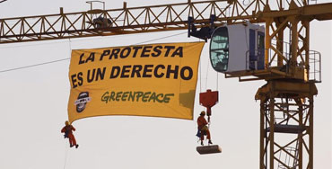 Activistas de Greenpeace colgados en una grúa cercana al Congreso contra la Ley Mordaza