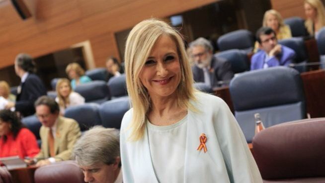 Cristina Cifuentes, engalanada con una bandera de España en la Asamblea.