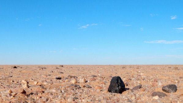 Fragmento negro del meteorito Almahata Sitta encontrado en el desierto de Nubia al norte de Sudán