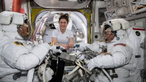 a astronauta de la NASA Christina Koch (centro) asiste a sus compañeros astronautas Nick Hague (izquierda) y Anne McClain (derechea) para ajustar sus trajes espaciales poco antes de comenzar su primer paseo espacial el pasado 22 de marzo