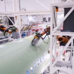 Un empleado de Airbus observa el trabajo de dos robots en el fuselaje de un modelo A320 en la planta de la empresa en Finkenwerder, al sur de Hamburgo