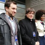 El expresidente catalán, Carles Puigdemont (centro), y su exconsejero de Sanidad, Toni Comín (izquierda) posan con sus credenciales de eurodiputados, el 20 de diciembre en Bruselas