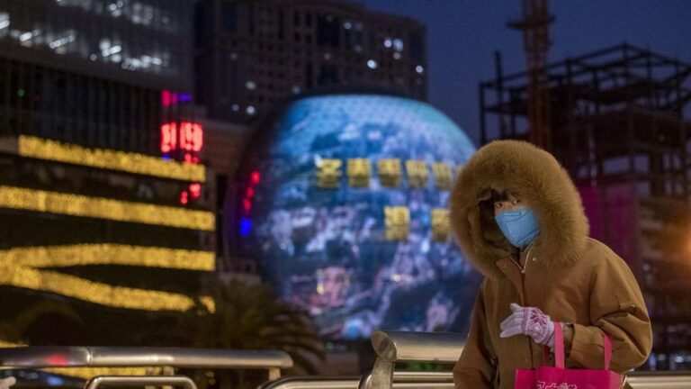 Una mujer pasea por las calles de Shangahi ataviada con una de las mascarillas que las autoridades chinas recomiendan llevar para evitar el contagio del nuevo coronavirus