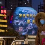 Una mujer pasea por las calles de Shangahi ataviada con una de las mascarillas que las autoridades chinas recomiendan llevar para evitar el contagio del nuevo coronavirus