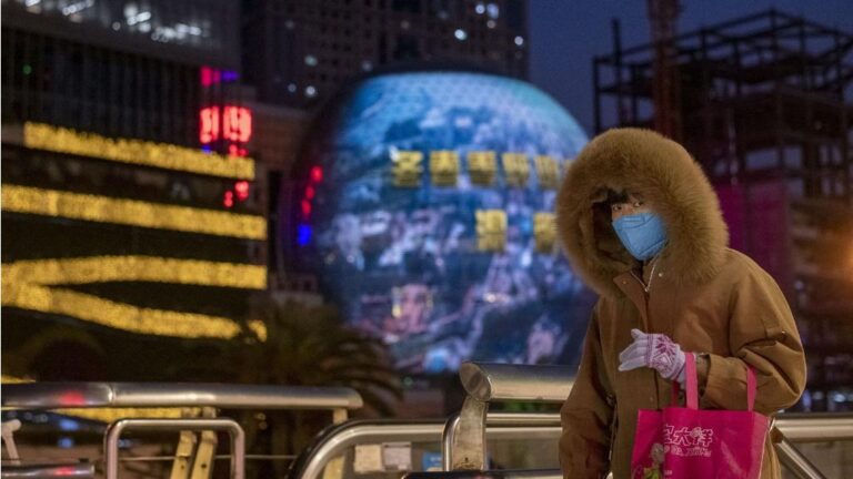 Una mujer pasea por las calles de Shangahi ataviada con una de las mascarillas que las autoridades chinas recomiendan llevar para evitar el contagio del nuevo coronavirus