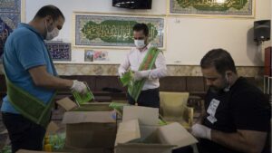 Voluntarios empaquetan productos desinfectantes y mascarillas ante el brote de nuevo coronavirus en Irán
