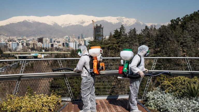 Trabajadores iraníes desinfectando un puente en Teherán