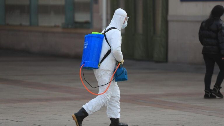 Un trabajador con un traje de protección en Pekín