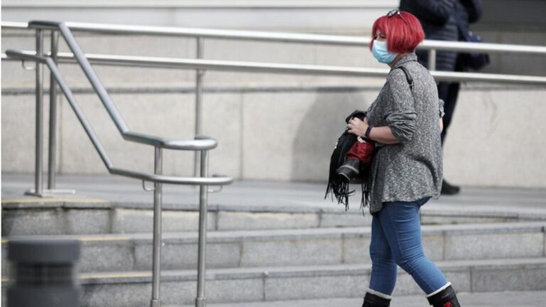 Una mujer protegida con mascarilla a las afueras del Hospital de la Paz