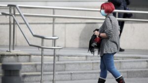 Una mujer protegida con mascarilla a las afueras del Hospital de la Paz