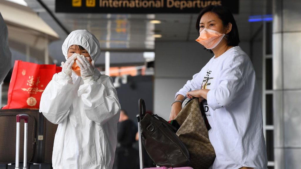 Dos pasajeras cubren sus rostros con mascarillas en el aeropuerto de Melbourne