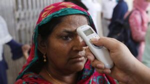 Funcionarios de las autoridades sanitarias de Bangladesh toma la temperatura a una mujer en Daca, la capital del país