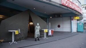 Un militar con traje de protección en el acceso de un hospital en la ciudad austriaca de Graz coronavirus