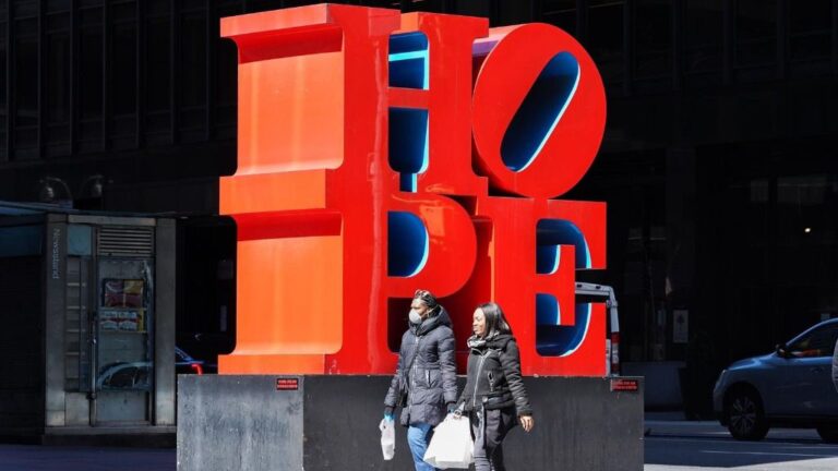 Dos mujeres pasean ante una escultura en Nueva York