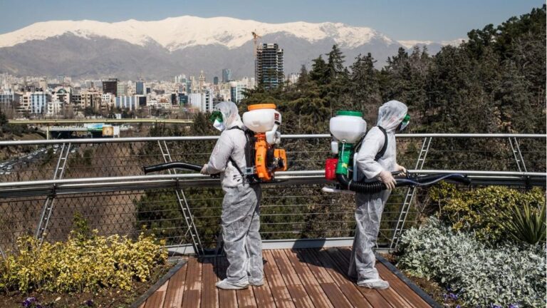 Trabajadores iraníes desinfectando un puente en Teherán