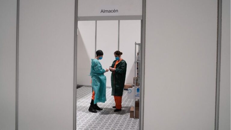 Dos trabajadores sanitarios hablan en las instalaciones del hospital de campaña instalado en IFEMA coronavirus