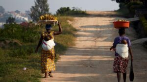 Dos mujeres caminan por un camino de Kigali, capital de Ruanda, portando sendas cestas de plátanos