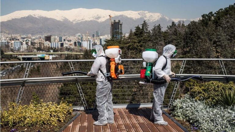 Trabajadores iraníes desinfectando un puente en Teherán