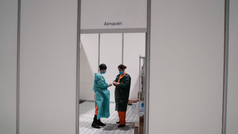 Dos trabajadores sanitarios hablan en las instalaciones del hospital de campaña instalado en IFEMA coronavirus