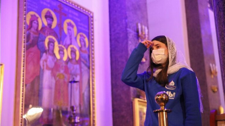 Una mujer con mascarilla en una catedral ortodoxa en San Petersburgo coronavirus