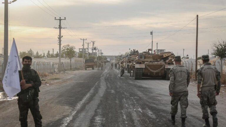 Soldados y vehículos militares de Turquía en una zona de estacionamiento para el Ejército y los rebeldes a los que apoya Ankara en Siria cerca de la frontera con el país árabe