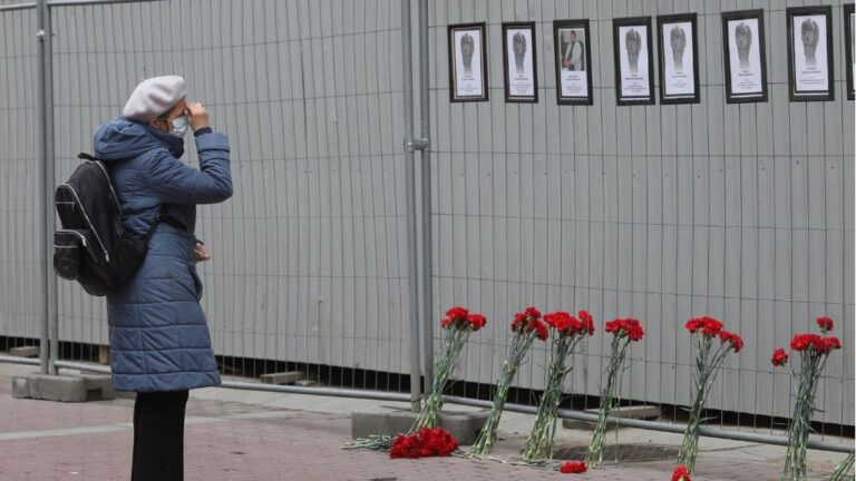 Una mujer ante un muro en el que se rinde homenaje a los trabajadores sanitarios fallecidos por el coronavirus en San Petersburgo