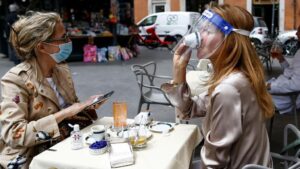 Dos personas sentadas en una terraza en Roma italia coronavirus