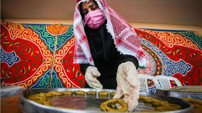 Una mujer palestina con mascarilla en Gaza preparando dulces tradicionales coronavirus