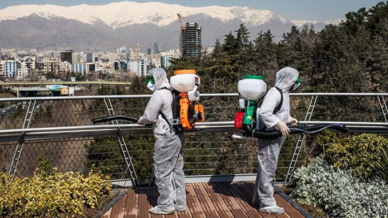 Trabajadores iraníes desinfectando un puente en Teherán