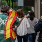 Un hombre con una bandera de España durante el cuarto día de protestas por la gestión del Gobierno en la crisis del coronavirus, frente a la sede del PSOE de la calle Ferraz en Madrid a 19 de mayo de 2020