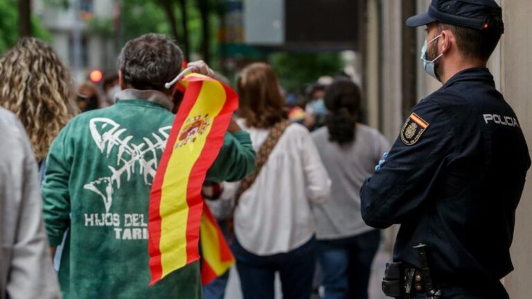 Un hombre con una bandera de España durante el cuarto día de protestas por la gestión del Gobierno en la crisis del coronavirus, frente a la sede del PSOE de la calle Ferraz en Madrid a 19 de mayo de 2020