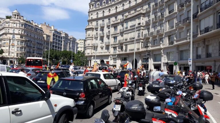 Personas y coches concentrados en la plaza Francesc Macià de Barcelona por la manifestación en coche de Vox