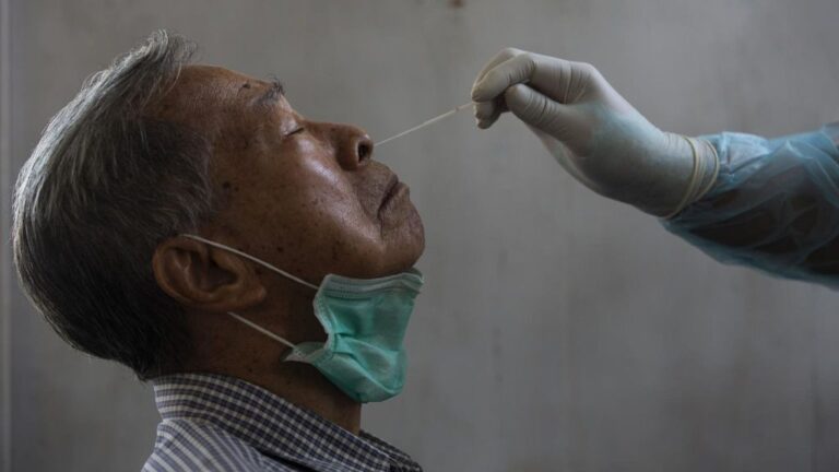 Un médico toma una muestra de un paciente para saber si tiene coronavirus.