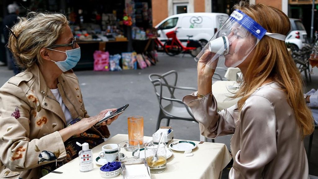 Dos personas sentadas en una terraza en Roma italia coronavirus