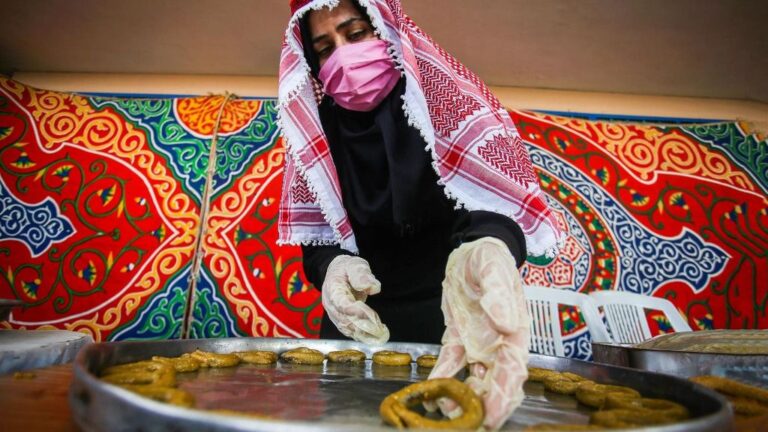 Una mujer palestina con mascarilla en Gaza preparando dulces tradicionales coronavirus