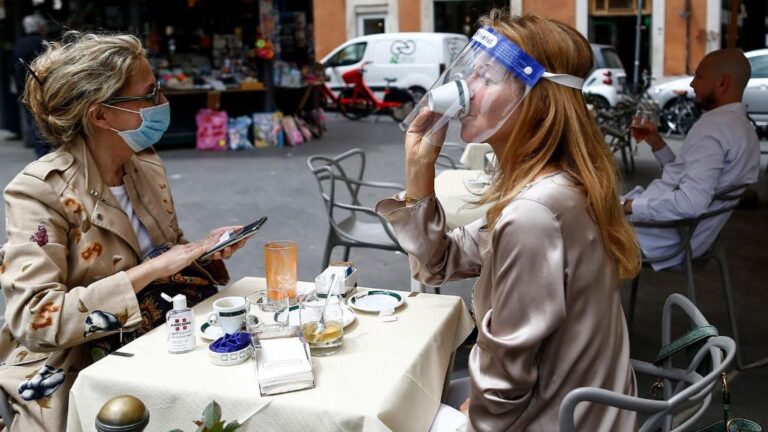 Dos personas sentadas en una terraza en Roma italia coronavirus