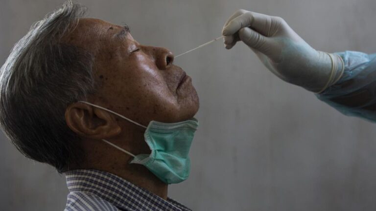 Un médico toma una muestra de un paciente para saber si tiene coronavirus.