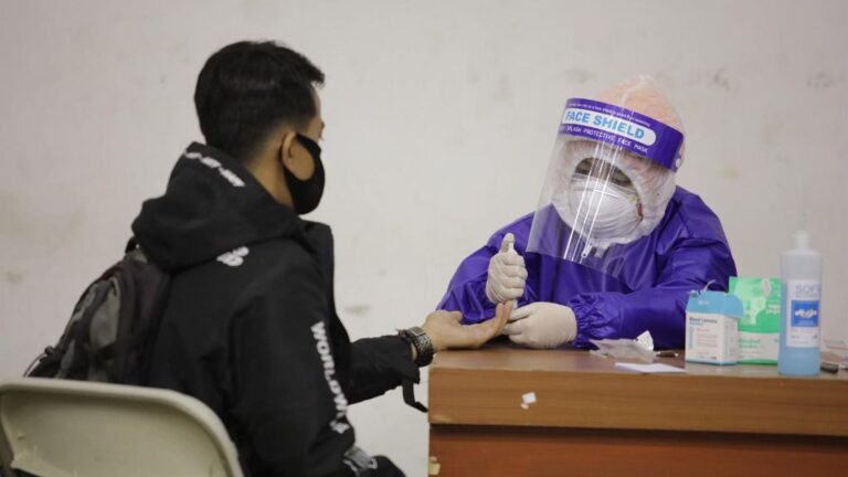 Un trabajador sanitario toma una muestra para una prueba de coronavirus en la localidad indonesia de Bandung