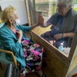 Una mujer en una residencia de ancianos recibe una visita en Bélgica coronavirus