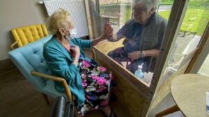 Una mujer en una residencia de ancianos recibe una visita en Bélgica coronavirus