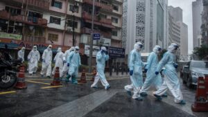 Trabajadores del Ministerio de Sanidad saliendo de un edifcio de Johannesburgo tras hacer pruebas de coronavirus a los vecinos