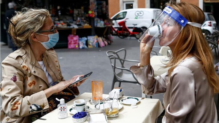 Dos personas sentadas en una terraza en Roma italia coronavirus