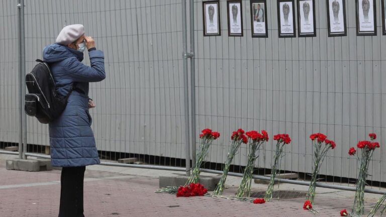 Una mujer ante un muro en el que se rinde homenaje a los trabajadores sanitarios fallecidos por el coronavirus en San Petersburgo