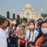 Turistas con mascarillas en una visita al Taj Mahal