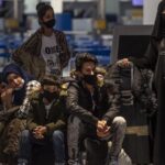 Migrantes y refugiado esperan para embarcar en Atenas rumbo a Londres