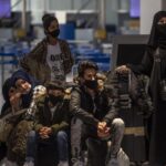 Migrantes y refugiados esperan para embarcar en Atenas rumbo a Londres