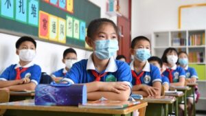 Niños chinos acuden a clase en Pekín china coronavirus