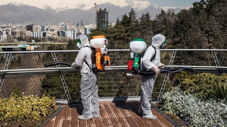 Trabajadores iraníes desinfectando un puente en Teherán